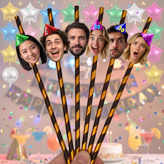 A set of six novelty birthday straws held by a hand, each decorated with a different person's face wearing a party hat with a number. The straws are dark brown with diagonal gold stripes, set against a festive, colorful party background with balloons, confetti, and a cake.