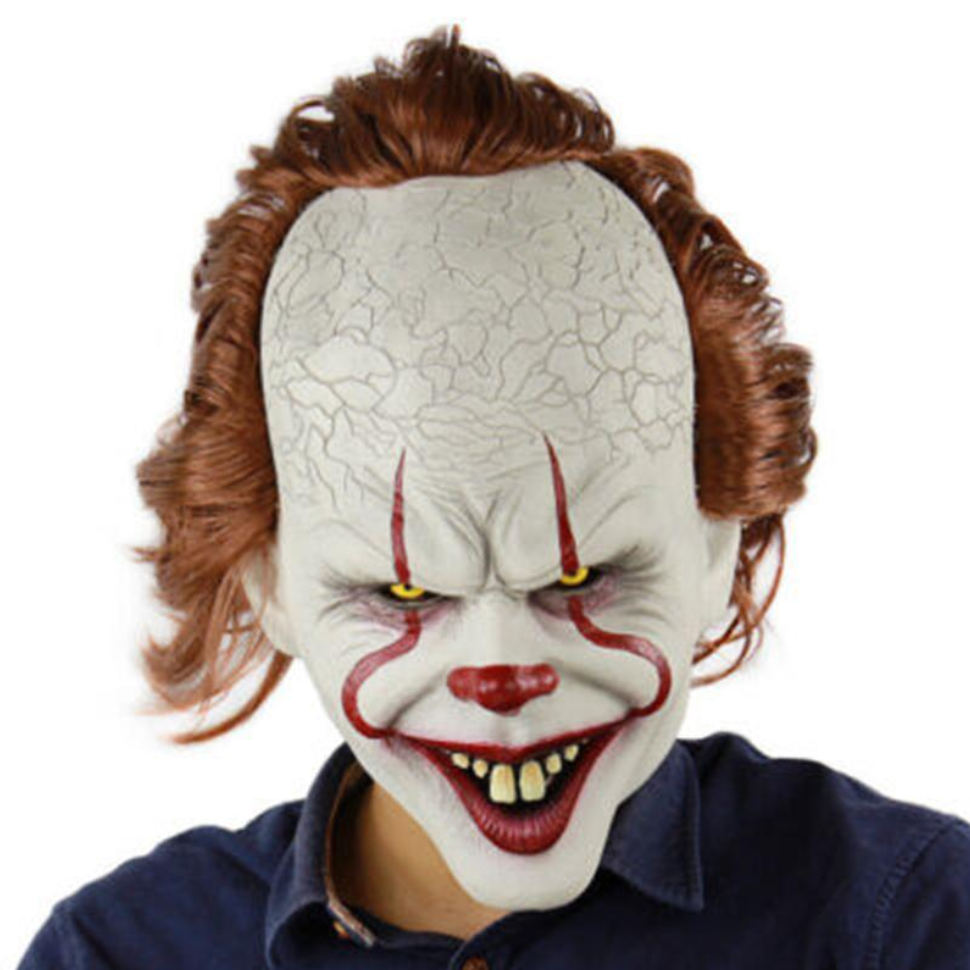 Person wearing a pennywise clown mask with red hair and a blue shirt on a white background